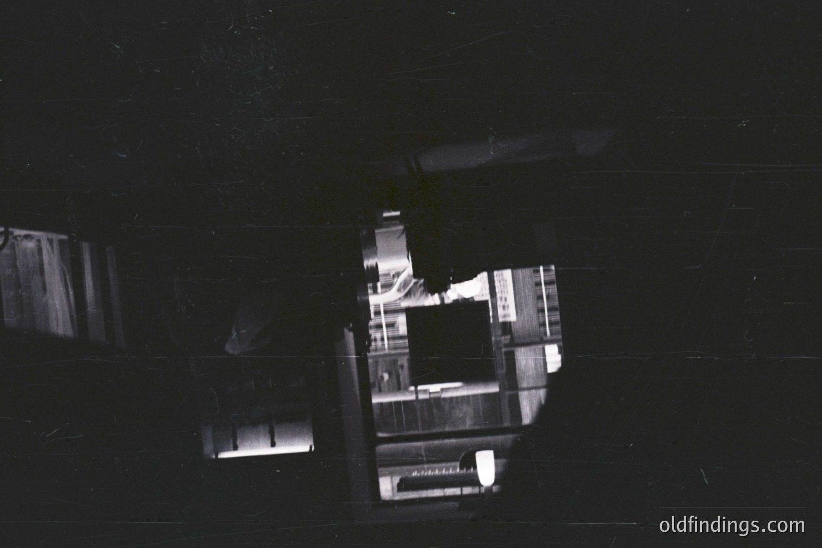 An intriguing view through an aperture, showcasing a street scene with blurred figures and vehicles. Architectural details are indistinct but suggest a European cityscape. High contrast, grainy texture, hinting at a mid-century (1960s-1970s) style. Likely used for design or abstract background elements.