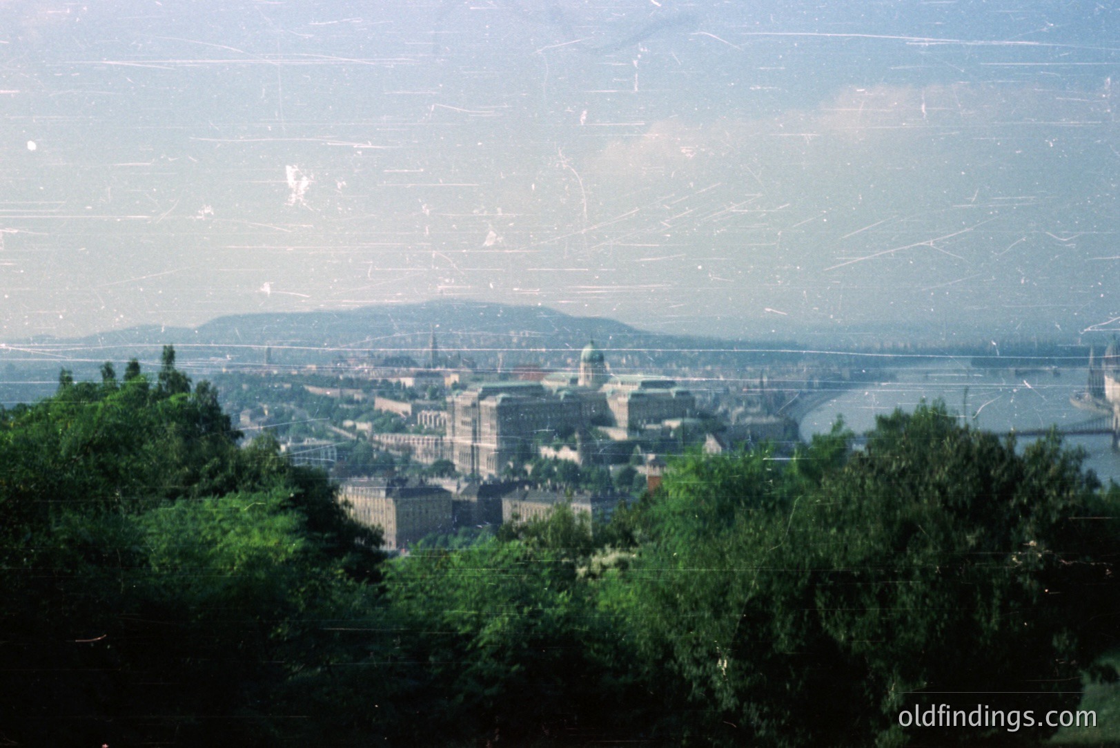 A panoramic view of Budapest, Hungary, showcasing the Danube River and cityscape. Notable buildings include the Buda Castle complex, visible with its distinctive architecture and dome. The Chain Bridge connects Buda and Pest. Likely taken in the 1970s given the film quality and visible infrastructure.