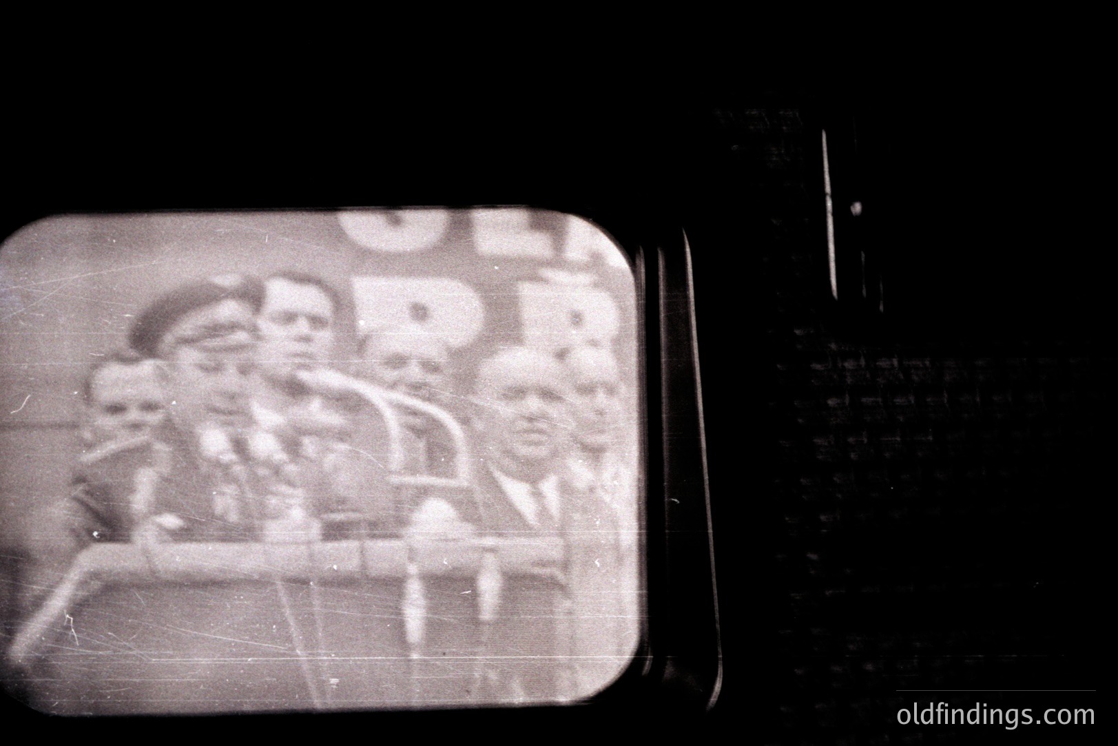 Vintage monochrome slide depicting a group of formally-dressed men, likely on a ship's deck. Visible are hats, jackets and a railing. Grainy texture and light leaks suggest age, likely a mid-20th century travel image. Potential stock photography reference for period design.