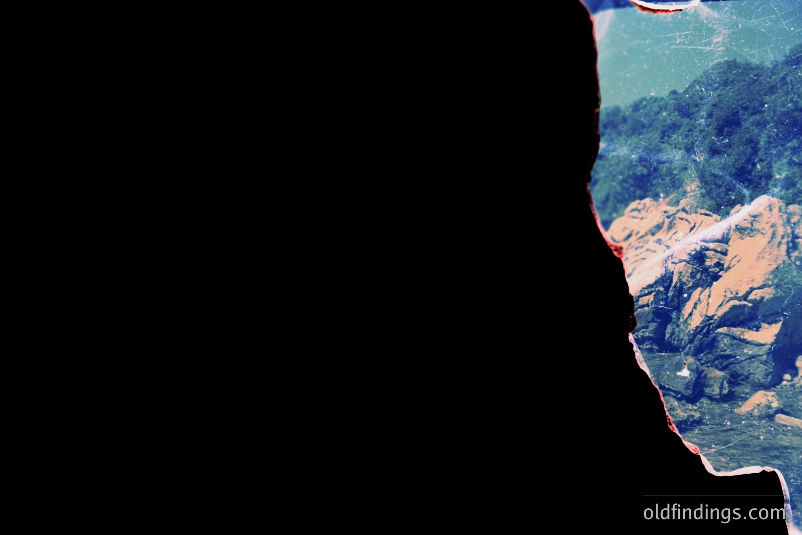 A partial view of a person facing a coastal landscape. The scene features red rock cliffs descending to a shoreline, visible through the partially obscured view. Photographic deterioration includes color shifts and dust/debris. Likely a travel snapshot, possibly 1970s.