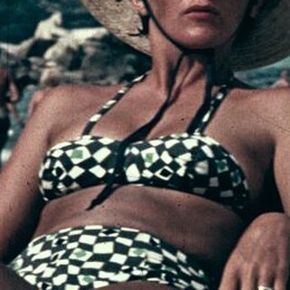Vintage beach scene with woman in straw hat and swimsuit.