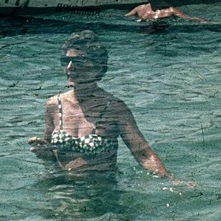 Vintage seaside scene with people swimming and boating.
