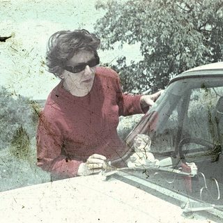 Woman opening car door in heavy rain.