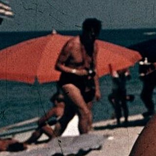 Woman relaxing on beach with hat.