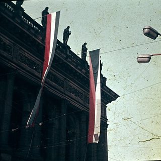 Vintage photo of traditional Asian building with flags and street lamps.