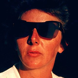 Person wearing sunglasses and light-colored shirt.