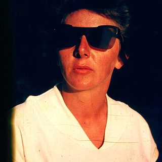 Person wearing sunglasses and light-colored shirt.
