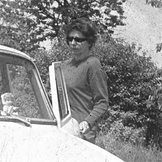 Vintage car with woman leaning in doorway.