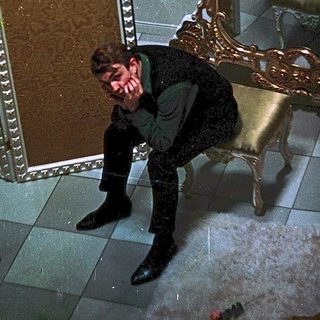 Man sitting on ornate chair in grand room.