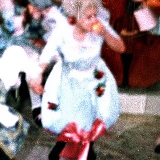 Children dancing in vintage-style costumes at a lively indoor party.
