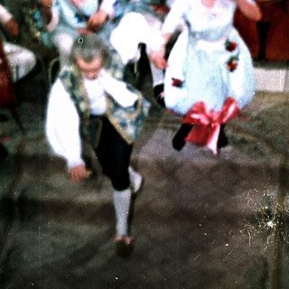 Children dancing in vintage-style costumes at a lively indoor party.