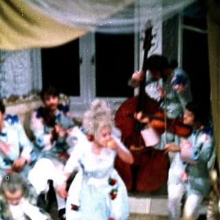 Children dancing in vintage-style costumes at a lively indoor party.