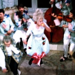 Children dancing in vintage-style costumes at a lively indoor party.