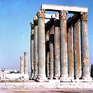 Ancient Greek temple ruins with tall Corinthian columns.