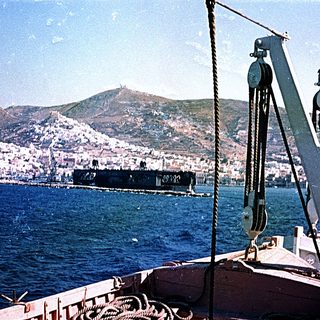Ship docked near coastal city port.