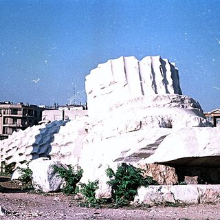 Massive unfinished marble blocks in urban quarry area.