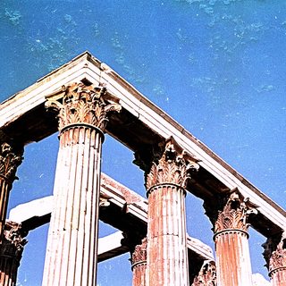 Ancient Corinthian-style columns under clear sky.
