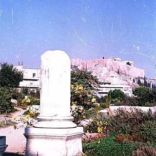 Ancient column with Acropolis ruins in background.