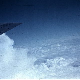 Airplane wing flying above clouds.