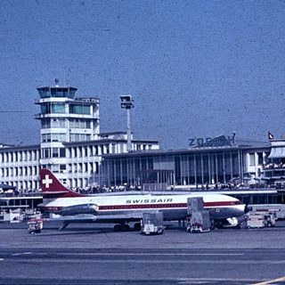 Airport terminal with Swissair plane and control tower.
