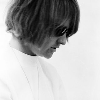 Young woman with short hair and sunglasses.