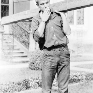 Young man talking on a vintage phone outdoors.