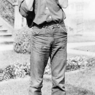 Young man talking on a vintage phone outdoors.