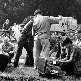 Film crew operating outdoor camera setup.