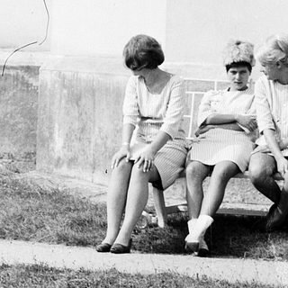 Three women sitting on steps outside a building.