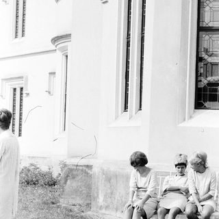 Three women sitting on steps outside a building.