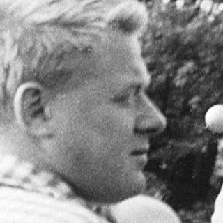Film crew operating vintage camera outdoors.