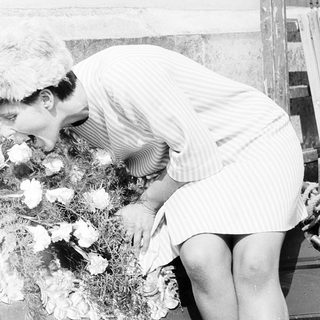 Person placing flowers on a casket.