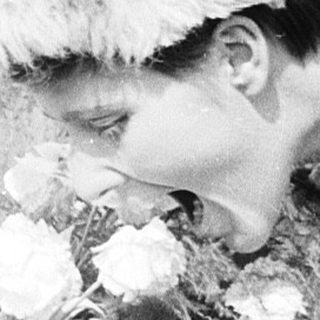 Person placing flowers on a casket.