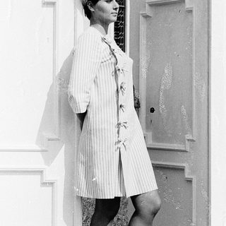 Woman in vintage striped robe and fur hat.