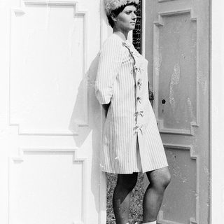 Woman in vintage striped robe and fur hat.