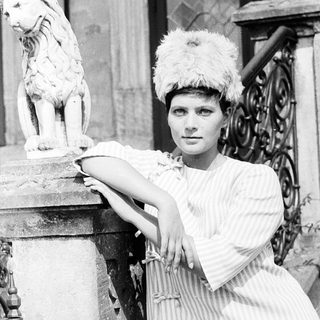 Elegant woman posing with lion statue.