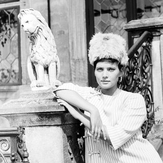 Elegant woman posing with lion statue.