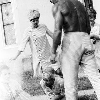Family playing outdoors in casual summer attire.