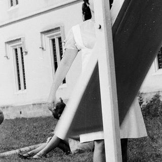 Two women gardening near a building.