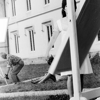 Two women gardening near a building.