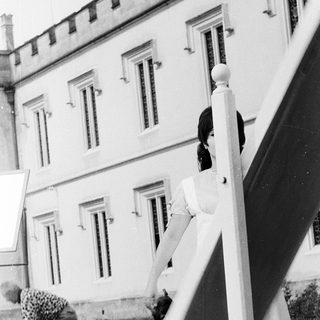 Two women gardening near a building.