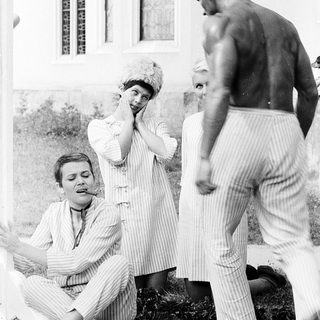 Vintage photo of three people in 1920s-style attire posing outdoors.
