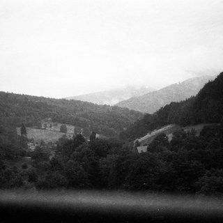 Mountainous landscape with historic building nestled in valley.