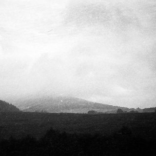 Misty landscape with distant hills and flat terrain.