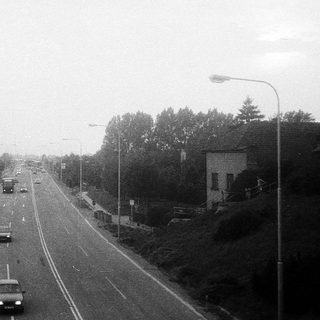 Empty highway with light traffic during overcast day.