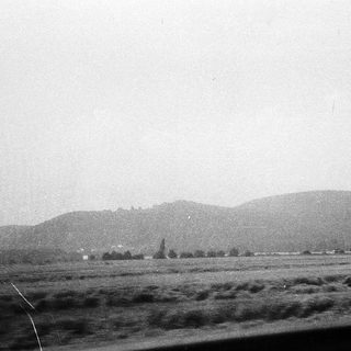 Rural landscape with distant hills and flat terrain.