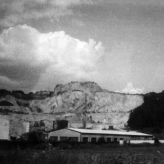 Industrial quarry site with extraction area and buildings.