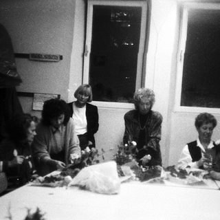 Group of people crafting floral arrangements indoors.
