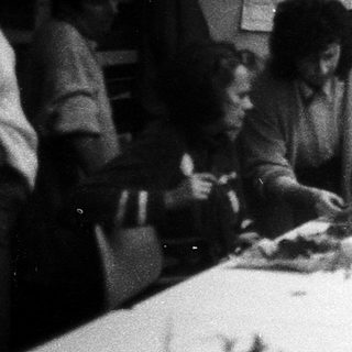 Group of people crafting floral arrangements indoors.