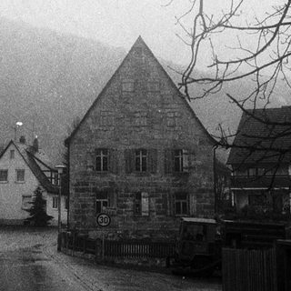 Misty village street with traditional stone houses.